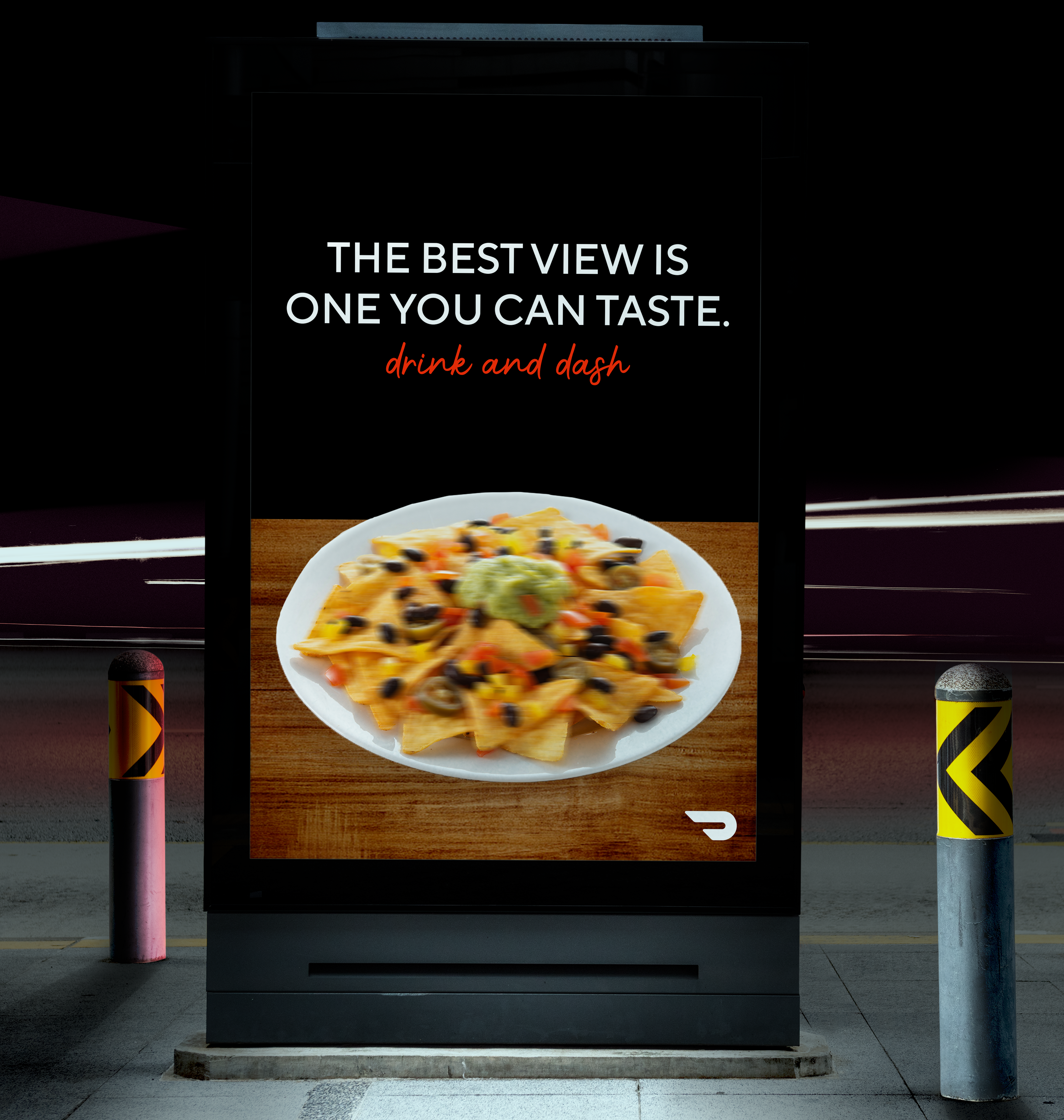 Mockup billboard ad. A picture of a blurry plate of nachos on a wooden table with a black background. The copy reads The best view is one you can taste.