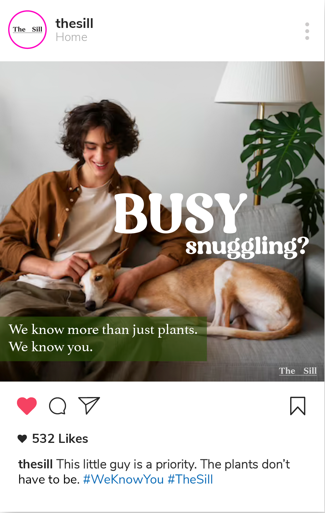 A mockup social post that featues a picture of a man sitting on a couch and snuggling his dog with text that reads Busy Snuggling? Text below reads We know more than just plants, we know you. The caption of the social post reads This little guy is a priority. The plants don't have to be